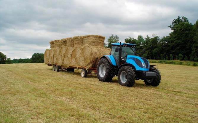 Трактор Landini з причепом транспортує тюки сіна